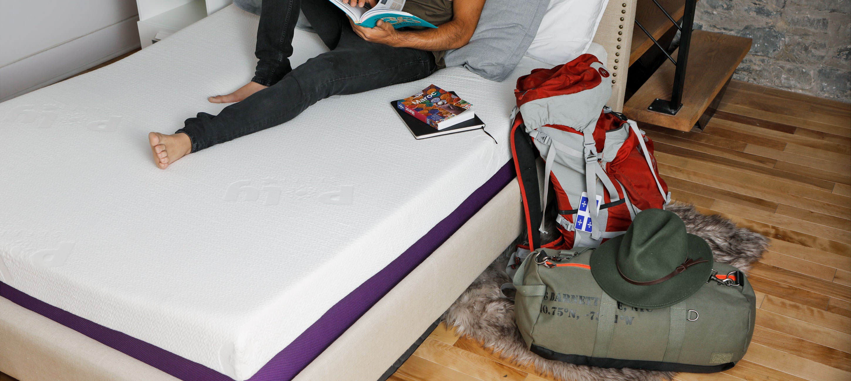 A Man is reading a book while sitting on his Polysleep mattress made in Quebec