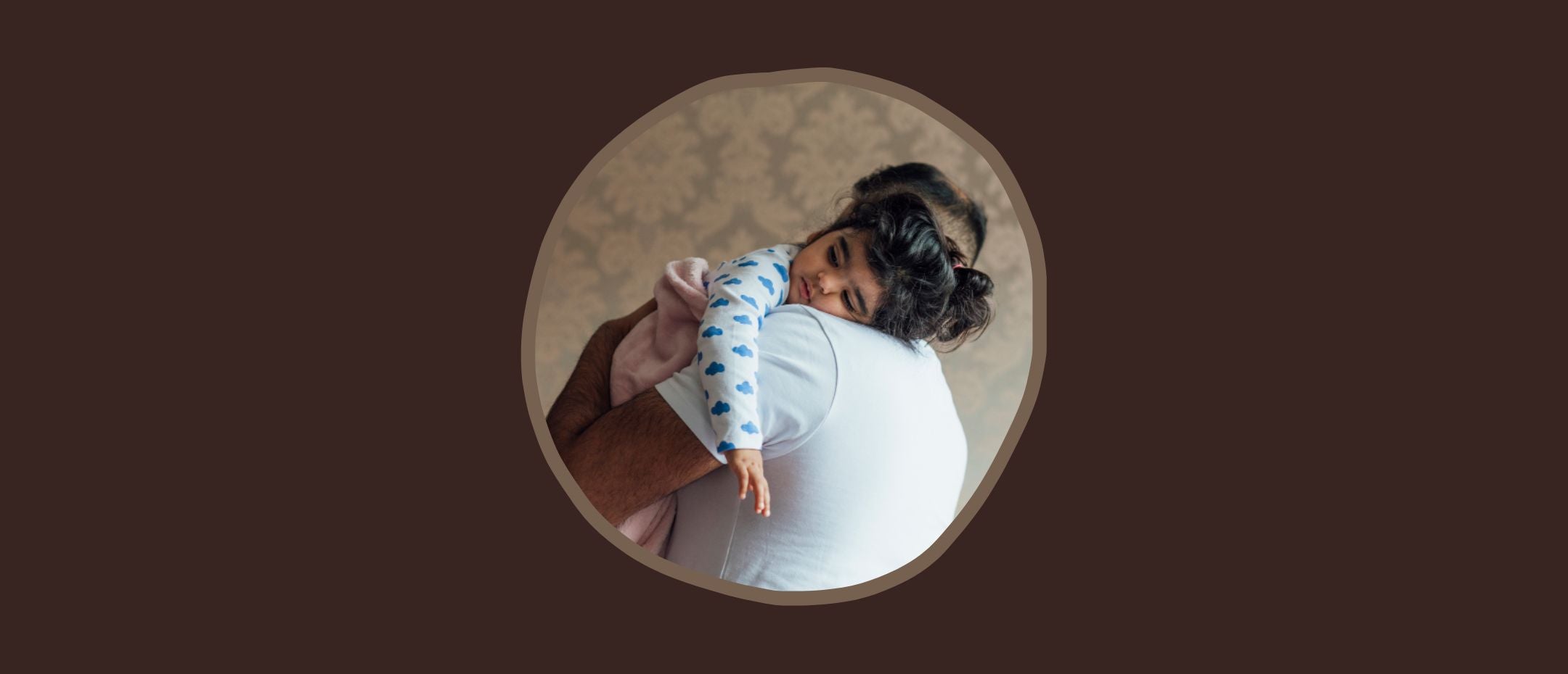 Overtired baby sleeps in his father's arms.