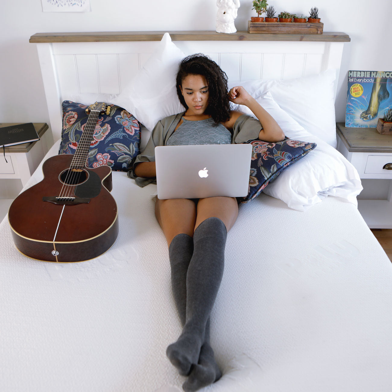 A satisfied customer is relaxing on the Polysleep foam mattress while using her laptop