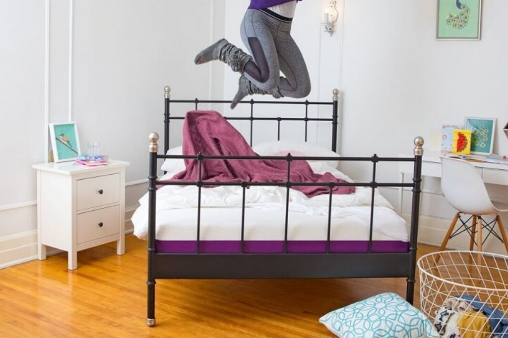 Person jumping on a bed