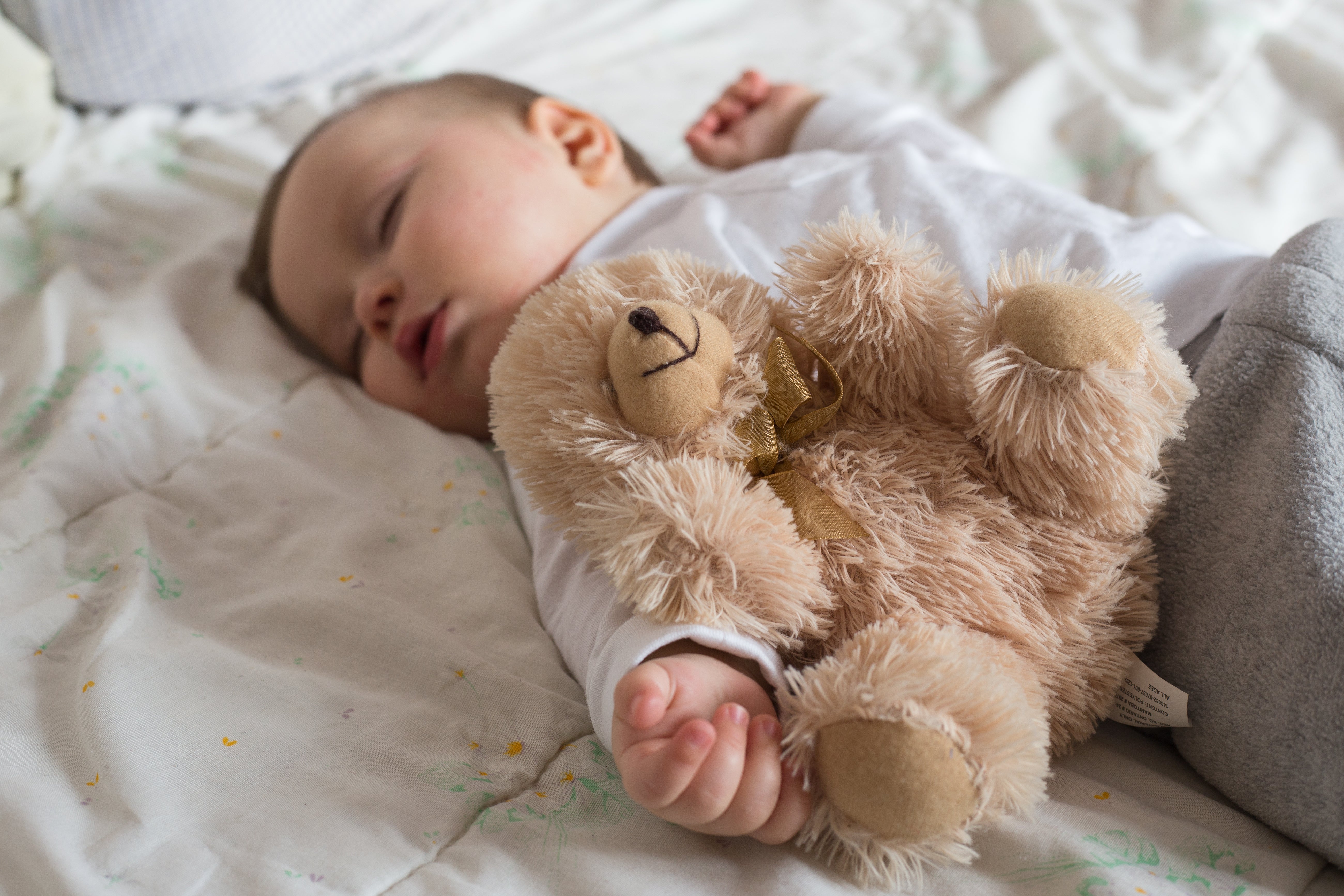 Baby sleeping with his teddy bear