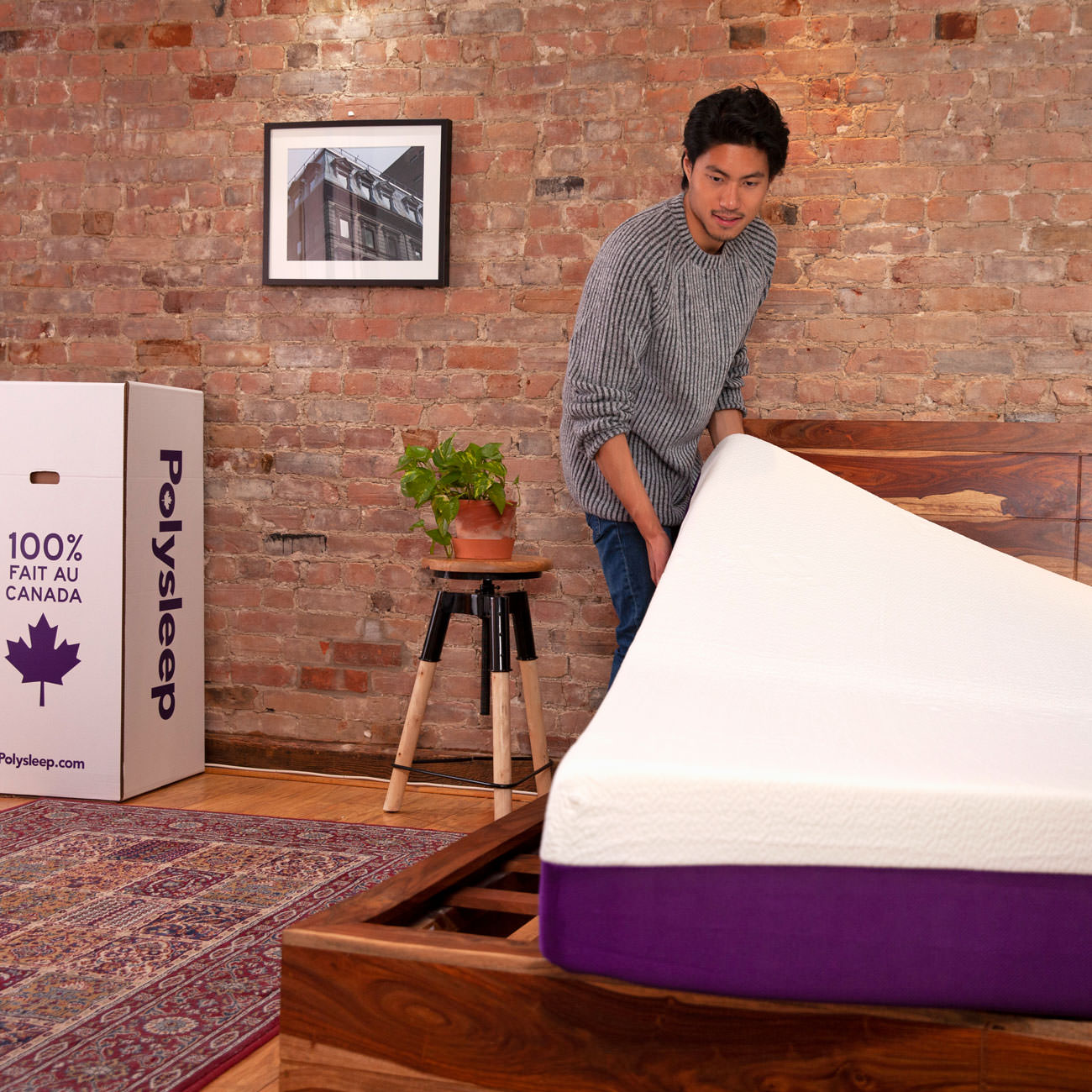 A customer is positioning his new Polysleep mattress on his bed