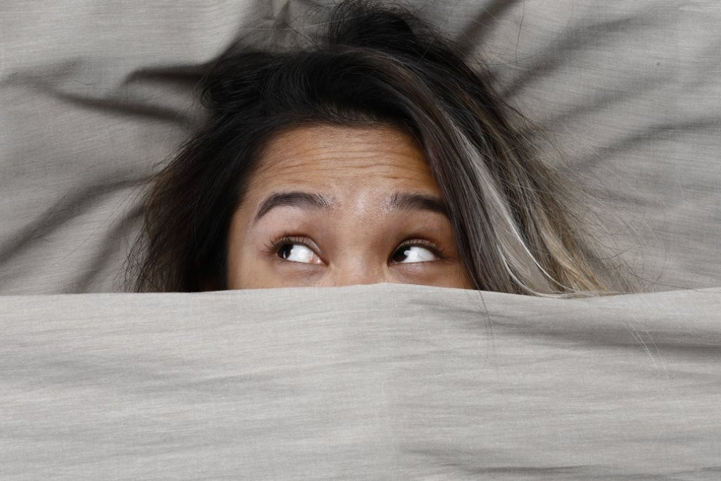Woman's head sticking out of under a blanket
