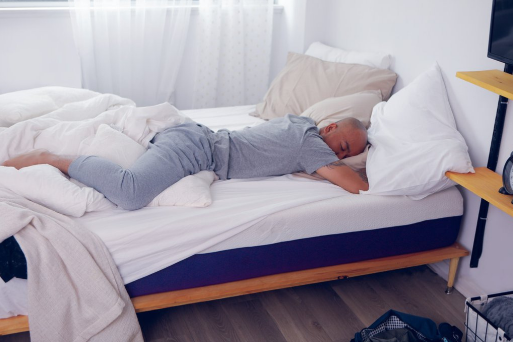 Man with white hair asleep in bed