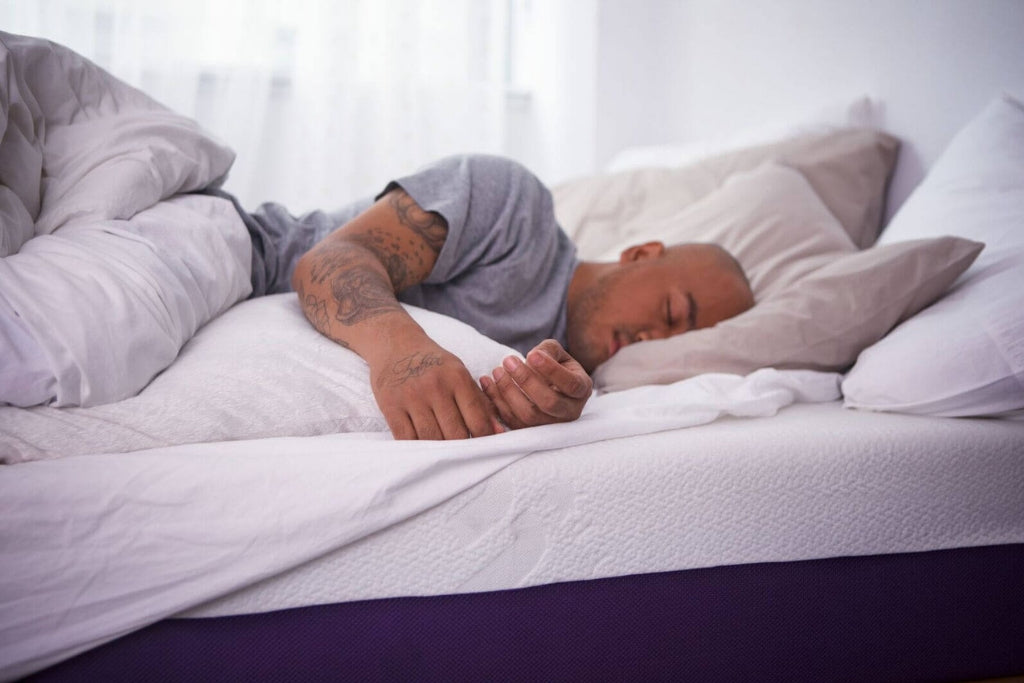 Tatooed man sleeping on a Polysleep mattress