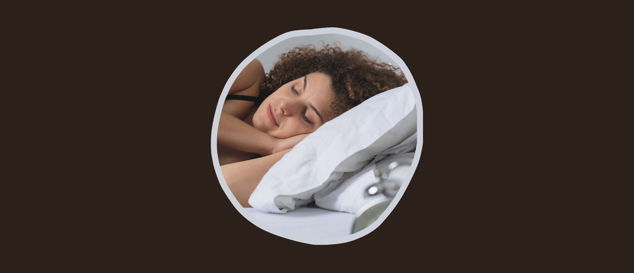 Femme avec les cheveux bouclés dormant dans son lit