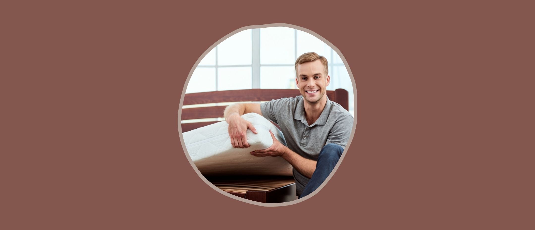 Happy man lifting the corner of a mattress to be moved