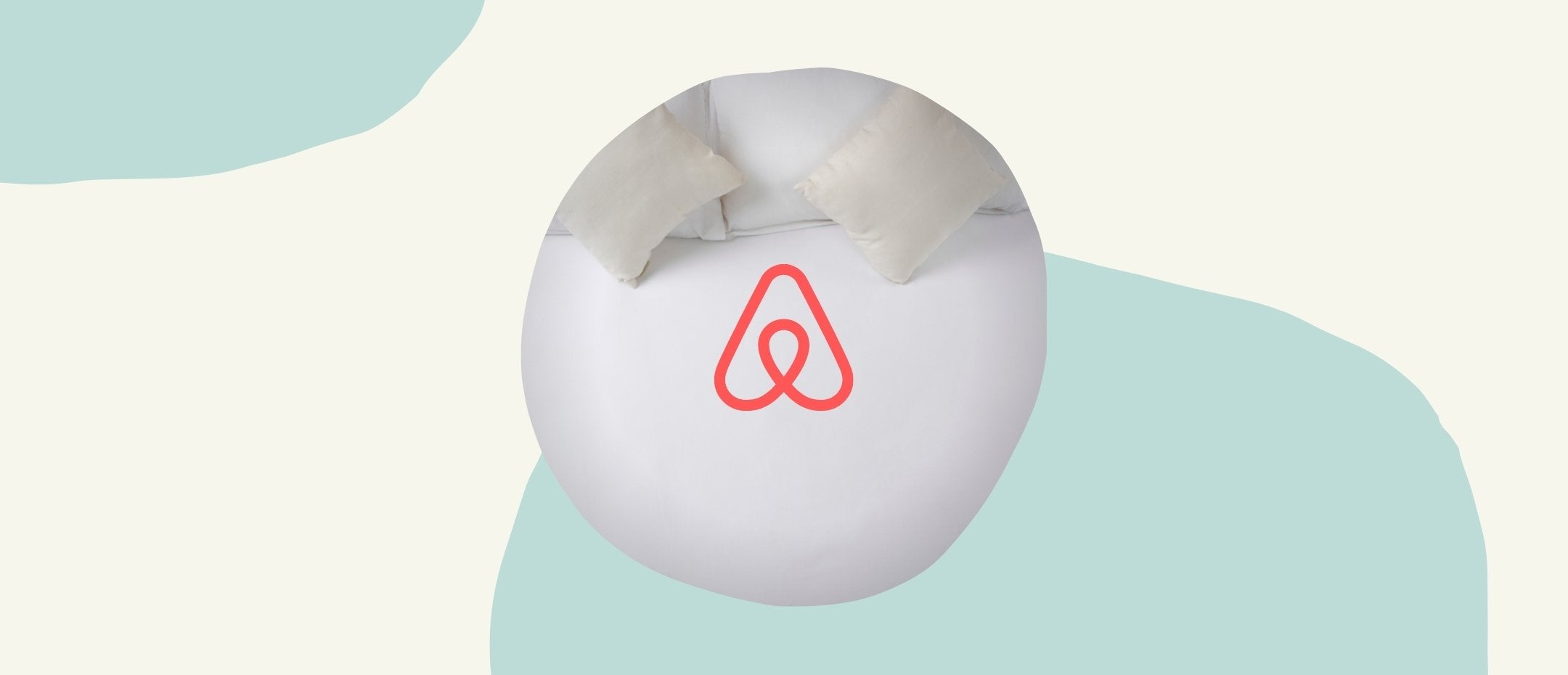 The Airbnb logo above a mattress including pillows