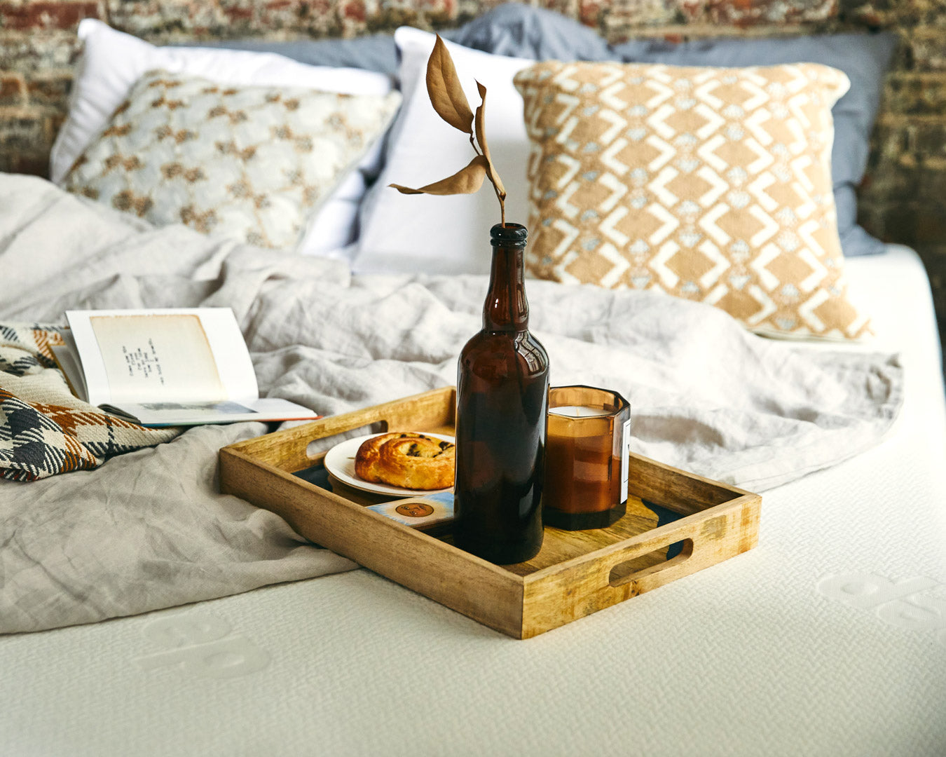 Un plateau déjeuner et un livre sont posés sur un lit Polysleep