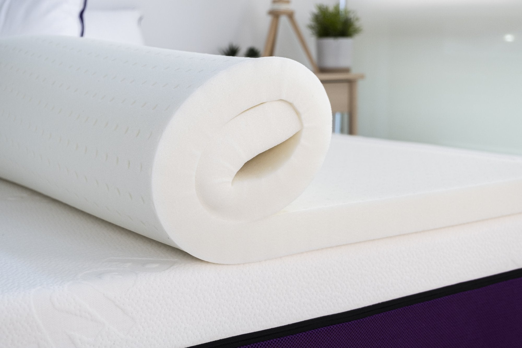 Polysleep antimicrobial mattress topper being rolled out on top of a mattress