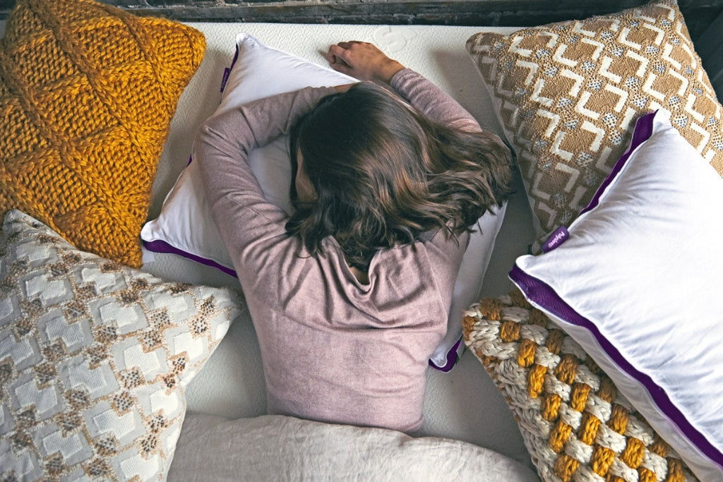 Sleeping woman surrounded by pillows
