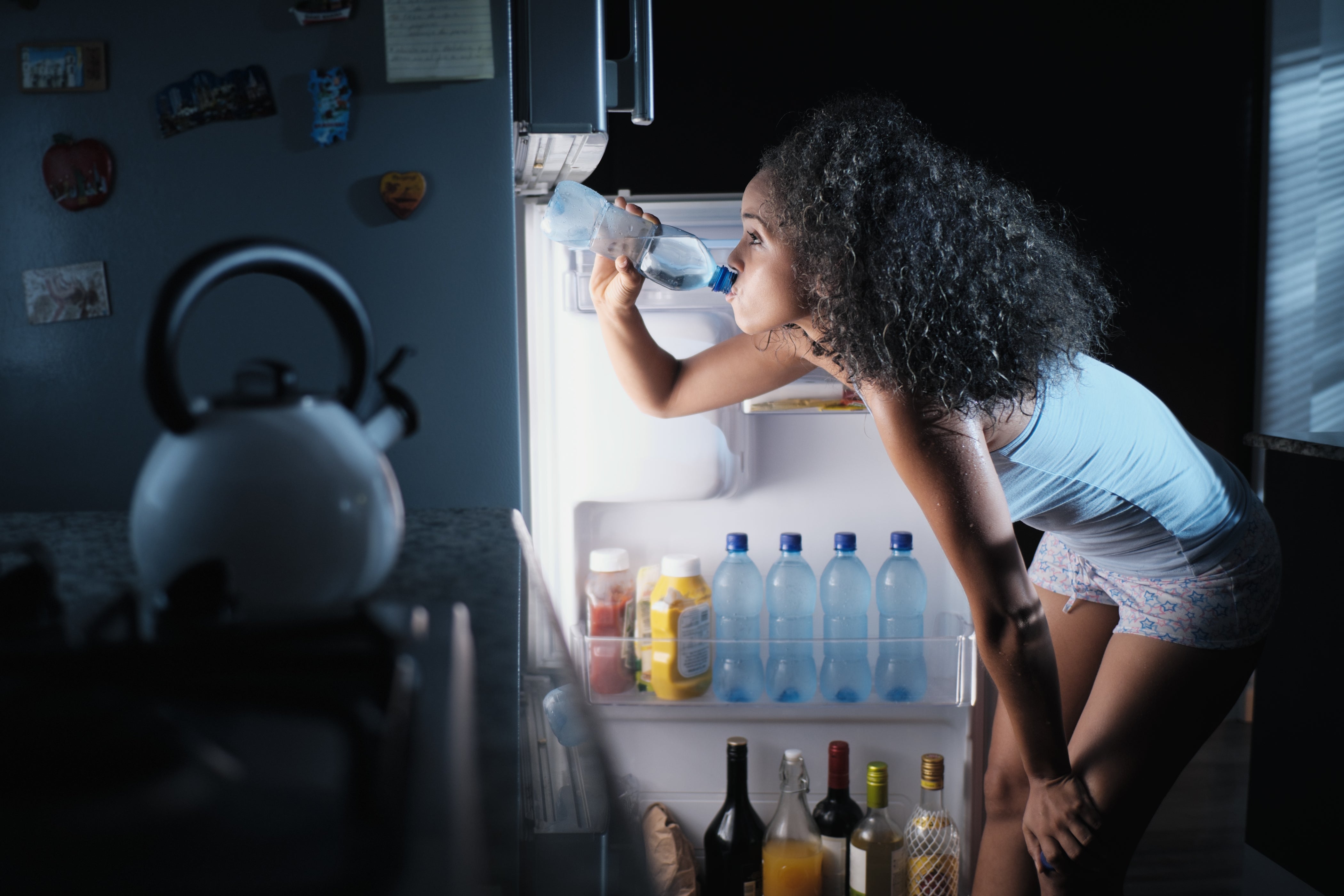 black woman sweating and drinking water at night