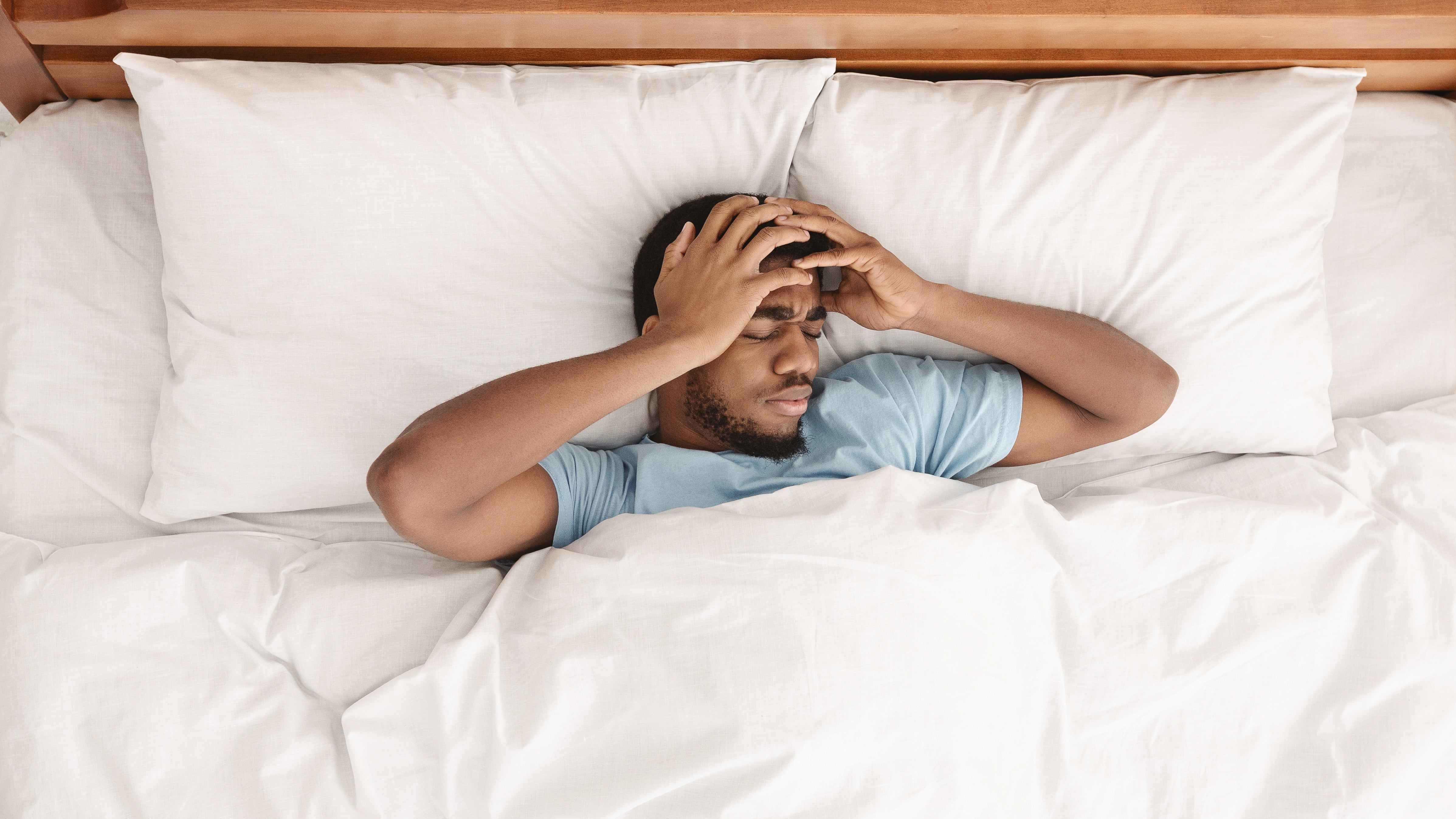 Man waking up with headache after a bad night